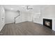 Open-concept living room featuring hardwood floors, staircase, fireplace, and neutral walls at 54 Silverleaf Dr, Wendell, NC 27591