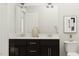 Modern bathroom with a dual sink vanity with dark cabinets, toilet and decorative mirror at 5640 Cayden Cove Dr, Wendell, NC 27591