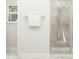 Bathroom featuring a glass-enclosed shower with neutral stone-like tiles, a towel rack, and a bright window at 5640 Cayden Cove Dr, Wendell, NC 27591
