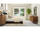Bright bedroom with a comfortable bed, stylish side table, large windows, and a plant at 5640 Cayden Cove Dr, Wendell, NC 27591
