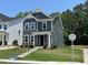 Charming two-story home with gray siding, stone accents, and lush green landscaping at 5640 Cayden Cove Dr, Wendell, NC 27591