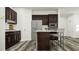Elegant kitchen with dark cabinetry, granite countertops, stainless steel appliances, and a kitchen island with bar stool seating at 5640 Cayden Cove Dr, Wendell, NC 27591