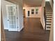 Open-concept living area with dark wood floors, staircase, and plenty of natural light at 5640 Cayden Cove Dr, Wendell, NC 27591