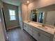 Bathroom featuring a double sink vanity with a large mirror and gray tiled floors at 5648 Cayden Cove Dr, Wendell, NC 27591