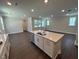 Kitchen island featuring white cabinets, quartz countertop and stainless sink, open to living space at 5648 Cayden Cove Dr, Wendell, NC 27591