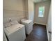 Laundry room with a window, shelving, dark wood-look flooring and a modern washer and dryer at 5648 Cayden Cove Dr, Wendell, NC 27591