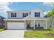 Two-story home featuring a spacious two car garage and a welcoming front porch at 571 White Birch Ln, Angier, NC 27501