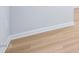 Corner detail of laminate flooring featuring white baseboards and white walls at 571 White Birch Ln, Angier, NC 27501