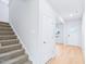 Hallway with stairs, carpet, white walls, and laminate flooring leading to door at 571 White Birch Ln, Angier, NC 27501