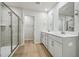 Light-filled bathroom featuring a glass shower and double vanity with modern hardware at 591 White Birch Ln, Angier, NC 27501
