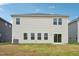 Rear exterior of the two-story home with vinyl siding, well-maintained lawn, and sliding glass doors to the backyard at 591 White Birch Ln, Angier, NC 27501