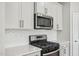Close up shot of a stainless microwave and glass top stove at 591 White Birch Ln, Angier, NC 27501