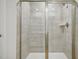 Bright shower features neutral tile surround and modern shower head with glass doors at 591 White Birch Ln, Angier, NC 27501