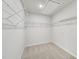 Spacious walk-in closet featuring adjustable white wire shelving system, and neutral carpeting for organization at 591 White Birch Ln, Angier, NC 27501
