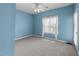 Light blue bedroom featuring a ceiling fan, neutral carpet, and lots of natural light at 6001 Winterpointe Ln # 204, Raleigh, NC 27606