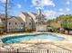 Community pool with surrounding brick detail, fencing, and a multi-story building in the background at 6001 Winterpointe Ln # 204, Raleigh, NC 27606