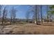 Expansive backyard featuring multiple houses and a fenced-in area, set against a backdrop of bare trees and a clear blue sky at 6089 Joe Trail Ct, Mebane, NC 27302