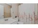 Simple bathroom with floral shower curtain, large mirror, and a white sink at 6089 Joe Trail Ct, Mebane, NC 27302