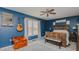 Rustic bedroom with dark blue walls, light wood floors, and wood furniture at 6089 Joe Trail Ct, Mebane, NC 27302