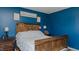 Bedroom featuring a wooden bed and navy walls at 6089 Joe Trail Ct, Mebane, NC 27302