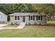 Charming single-story home with a well-manicured lawn, freshly mulched flower beds, and updated siding at 610 Pineland St, Sanford, NC 27330