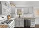 Bright kitchen with white cabinets, stainless steel appliances, and granite countertops at 628 Woods Mill Cir, Wake Forest, NC 27587