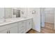 Bathroom with double sink vanity, white cabinets and a large mirror at 65 Hickory Run Ln, Franklinton, NC 27525