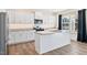 View of a bright kitchen featuring an island with white cabinets, granite countertops and stainless appliances at 65 Hickory Run Ln, Franklinton, NC 27525