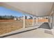 View of covered back patio with concrete flooring that overlooks an expansive backyard and neighborhood homes at 65 Hickory Run Ln, Franklinton, NC 27525