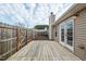 Inviting back deck featuring a classic chimney, pristine white French doors, and privacy fence at 653 Huntingdon St, Elon, NC 27244