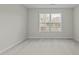Bright, carpeted bedroom with a large window offering plenty of natural light and a view of the outdoors at 653 Huntingdon St, Elon, NC 27244