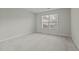 Bright, carpeted bedroom with a large window offering plenty of natural light and a view of the outdoors at 653 Huntingdon St, Elon, NC 27244