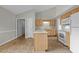 Bright kitchen with light wood cabinetry, a central island, and white appliances under a vaulted ceiling at 653 Huntingdon St, Elon, NC 27244