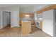 Spacious kitchen with wood cabinets, a central island, and white appliances beneath a vaulted ceiling at 653 Huntingdon St, Elon, NC 27244