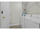 A functional laundry room with washer, dryer, shelving, and door at 653 Huntingdon St, Elon, NC 27244