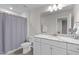 Bathroom has a white vanity with granite countertops, a gray shower curtain, and gray tile floors at 656 Dallas Rose Dr, Wendell, NC 27591