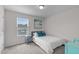 Bright bedroom features a bed with white comforter, blue throw pillows, and a window at 656 Dallas Rose Dr, Wendell, NC 27591