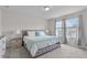 Bright main bedroom featuring large windows, neutral decor, and a comfortable upholstered bed for a relaxing retreat at 656 Dallas Rose Dr, Wendell, NC 27591