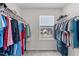 Spacious walk-in closet with ample shelving and hanging space, offering well-organized storage with a view to the neighborhood at 656 Dallas Rose Dr, Wendell, NC 27591