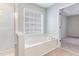 Bright primary bathroom showcasing soaking tub, window, and shower in an alcove at 7533 Silver View Ln, Raleigh, NC 27613