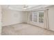 A spacious primary bedroom featuring neutral walls and carpet, tray ceiling, and a large window for natural light at 7533 Silver View Ln, Raleigh, NC 27613