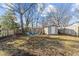 Fenced backyard with mature trees and a firepit featuring adirondack chairs surrounding a firepit at 805 N Elizabeth St St, Durham, NC 27701