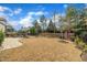 Landscaped backyard featuring manicured lawn, fire pit, seating area, and fence at 8304 Rosiere Dr, Cary, NC 27518