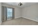 This bedroom features neutral carpet, window, and a modern ceiling fan at 8304 Rosiere Dr, Cary, NC 27518