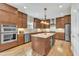 Bright kitchen with custom cabinets, stainless appliances, center island, and hardwood floors at 8304 Rosiere Dr, Cary, NC 27518