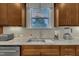 Close-up of kitchen sink with granite counters, stainless appliances, and view to backyard at 8304 Rosiere Dr, Cary, NC 27518