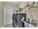 An organized laundry room provides shelving, a sink, and modern appliances for efficient cleaning at 8304 Rosiere Dr, Cary, NC 27518
