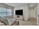 Comfortable living room features a modern media console and large windows that let in natural light at 8304 Rosiere Dr, Cary, NC 27518