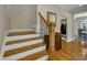 Staircase with wooden steps, white risers, and a wrought iron and wood banister at 8304 Rosiere Dr, Cary, NC 27518
