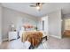 Serene bedroom with a ceiling fan, neutral tones, and a view into the walk-in closet and en-suite bathroom at 833 Providence Glen Dr, Chapel Hill, NC 27514